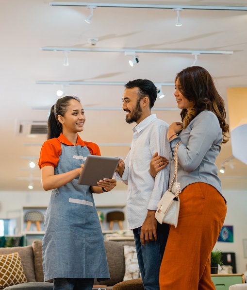 Female shop assistant chatting with a married customer at a furniture store